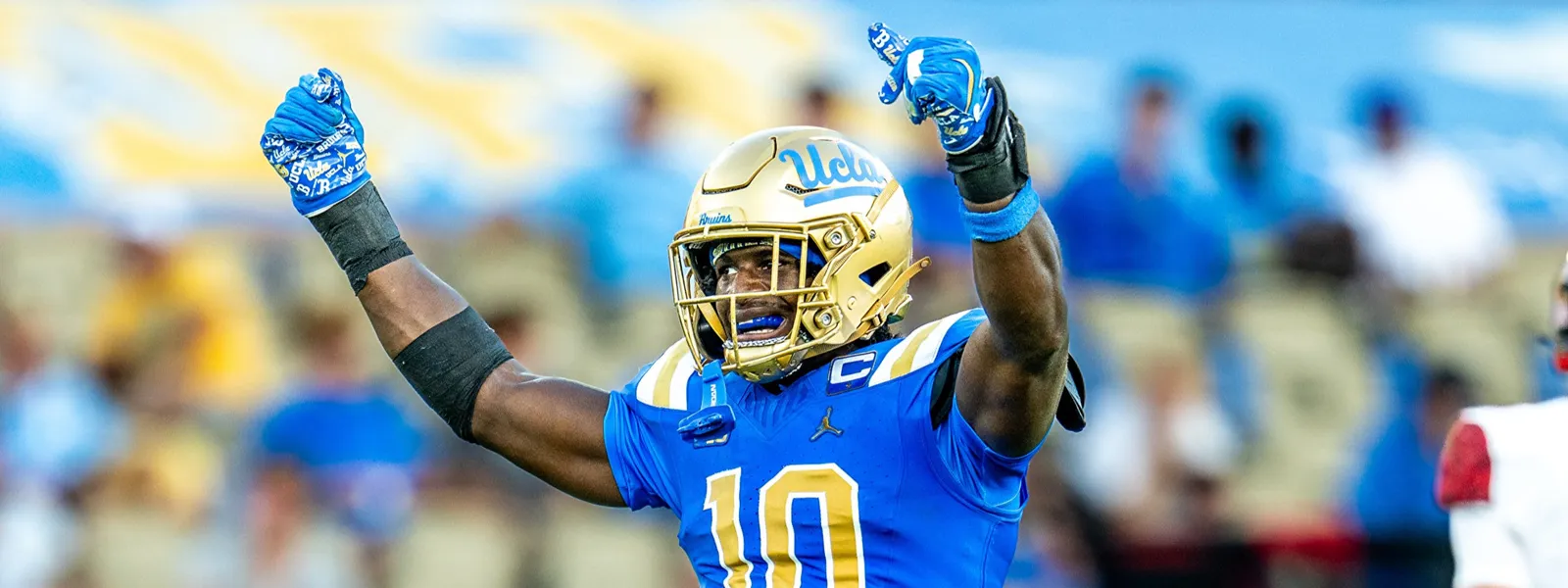 Linebacker Sammy Omosigho raises his arms to celebrate a play