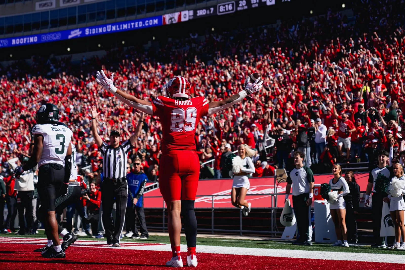 Jacob Harris raises his arms after a Wisconsin touchdown against Michigan State